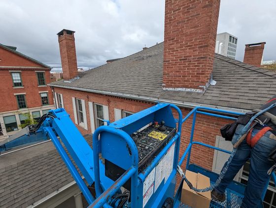 Crew working from a lift on a brick building